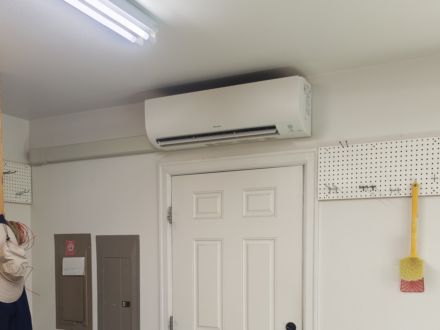 Indoor Daikin mini-split head installed above a garage entry door
